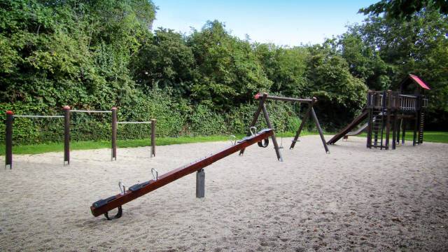 Spielplatz mit Wippe im Vordergrund des Bildes