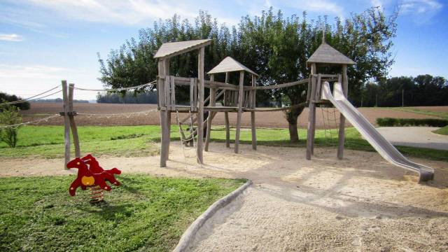 Klettergerüst aus Holz mit Rutsche, bei sonnigem Wetter